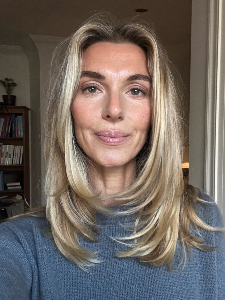 Woman with blonde hair wearing a blue jumper